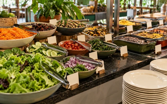 Buffet por quilo com saladas, pratos variados e pegadores compartilhados